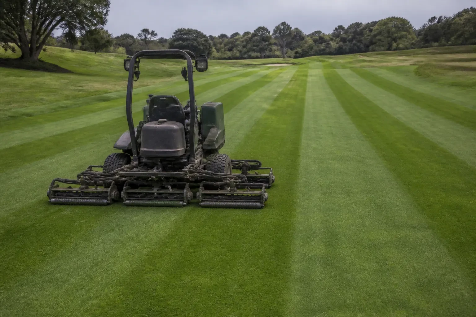 Used golf course maintenance equipment in a turf yard